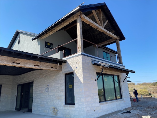 view of side of property with a balcony