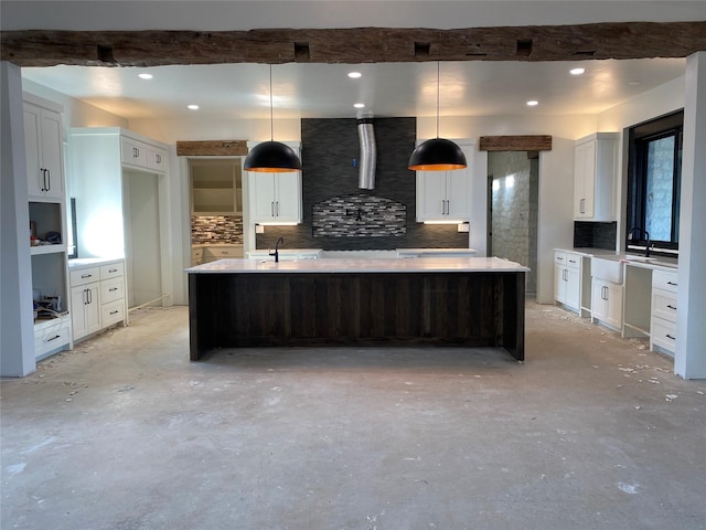 kitchen featuring hanging light fixtures, decorative backsplash, wall chimney exhaust hood, and a spacious island