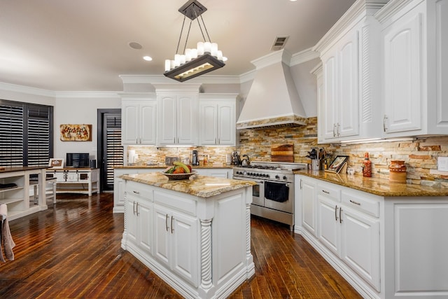 kitchen featuring hanging light fixtures, double oven range, premium range hood, white cabinetry, and a center island