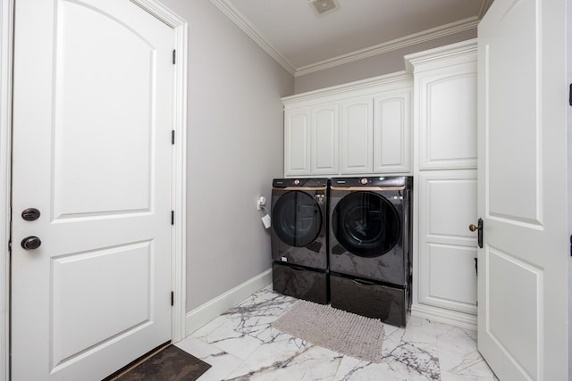 clothes washing area featuring cabinets, ornamental molding, light tile floors, and washing machine and clothes dryer