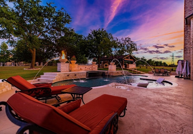 pool at dusk with a lawn and a patio