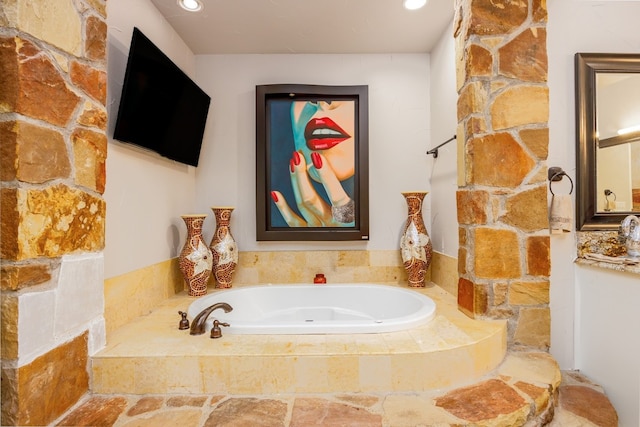 bathroom featuring a relaxing tiled bath