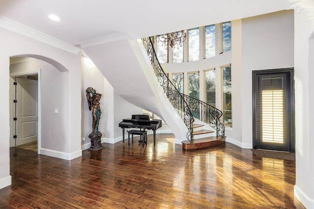 entryway featuring dark hardwood / wood-style floors, ornamental molding, and a notable chandelier