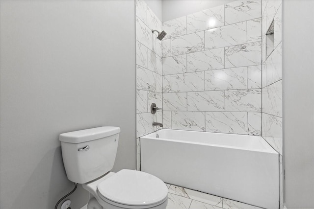 bathroom featuring toilet and tiled shower / bath