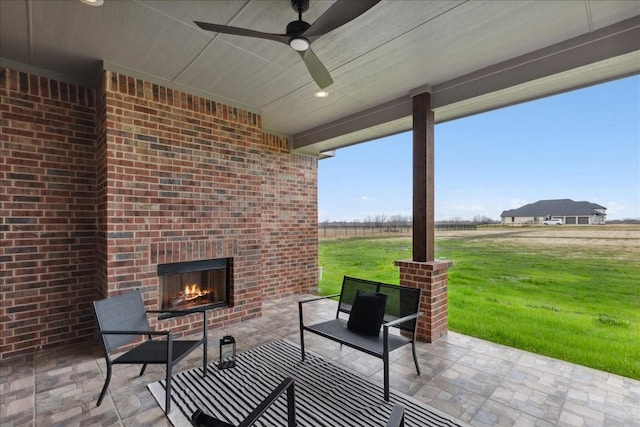 view of patio featuring ceiling fan and an outdoor brick fireplace