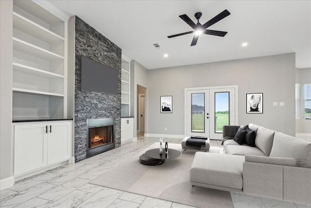 living room featuring ceiling fan, a fireplace, french doors, and built in shelves