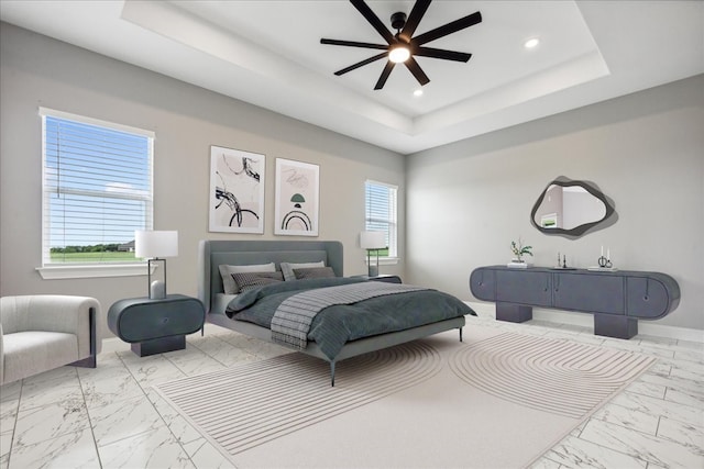 bedroom featuring ceiling fan and a tray ceiling