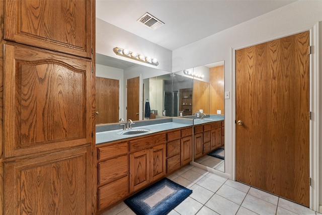 bathroom with double vanity, tile patterned flooring, a sink, and visible vents