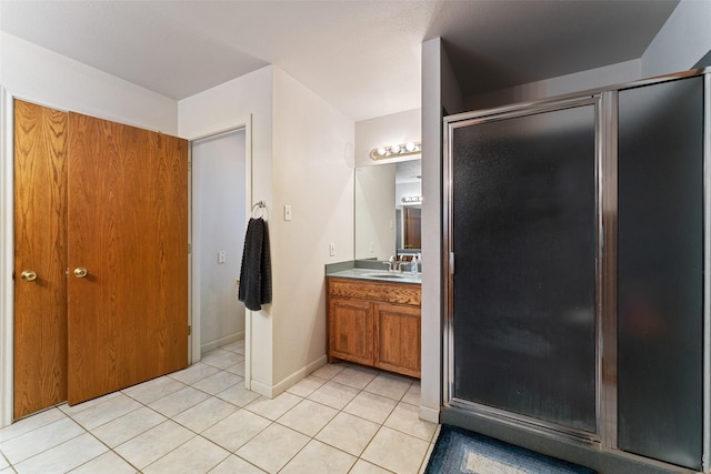 bathroom featuring tile patterned flooring, baseboards, vanity, and a shower stall