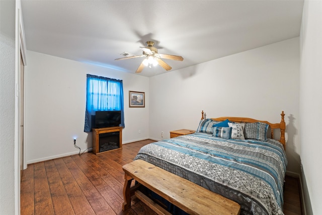 bedroom with ceiling fan, baseboards, and dark wood finished floors