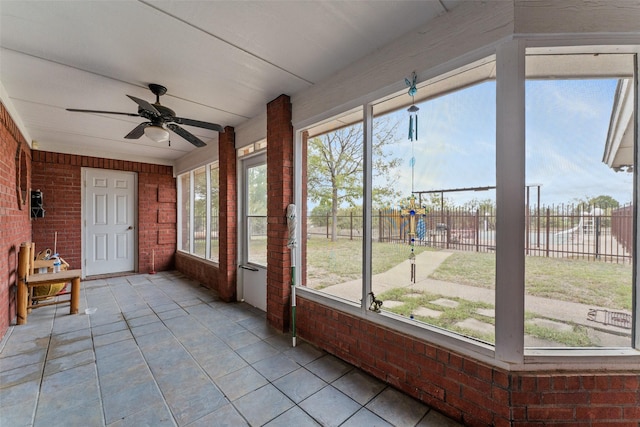 unfurnished sunroom with a ceiling fan