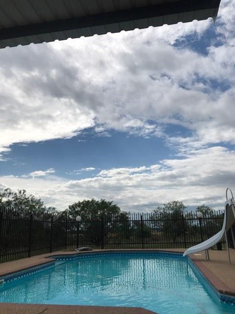 view of swimming pool with a water slide, fence, and a fenced in pool