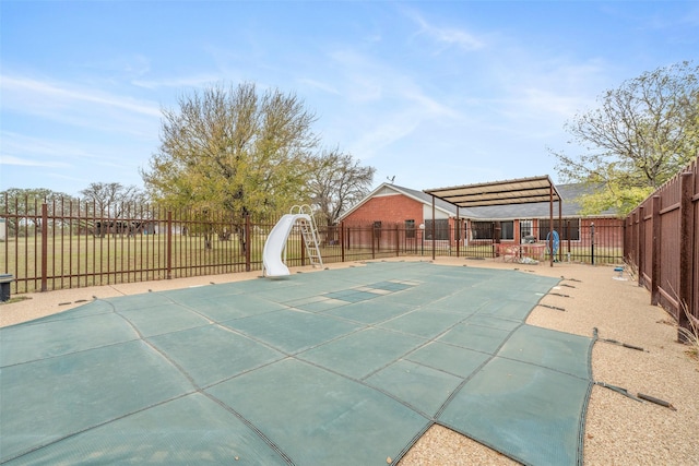 view of swimming pool with a fenced in pool, a water slide, a fenced backyard, and a pergola