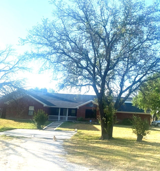 view of front facade with driveway, a porch, and a front yard