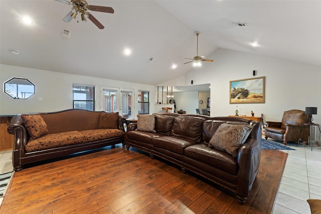 living area featuring high vaulted ceiling, wood finished floors, visible vents, and a ceiling fan