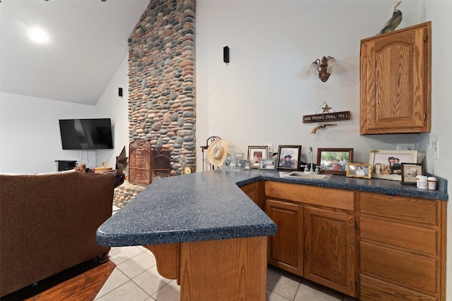 kitchen featuring dark countertops, brown cabinets, a sink, and light tile patterned flooring