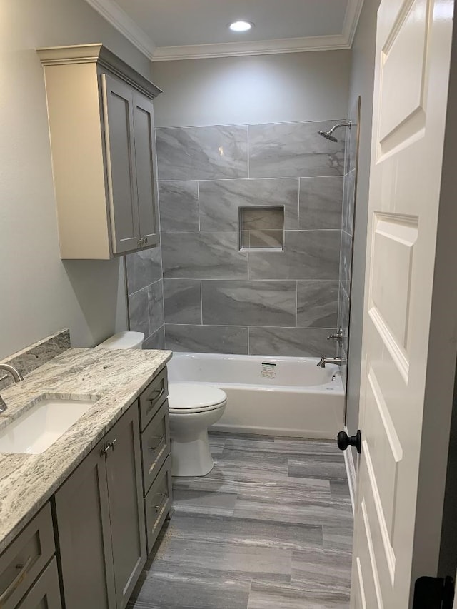 full bathroom with crown molding, vanity, toilet, and tiled shower / bath combo