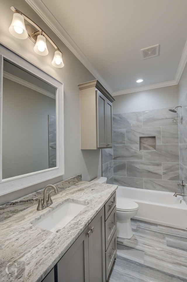 full bathroom featuring tiled shower / bath, ornamental molding, toilet, and vanity