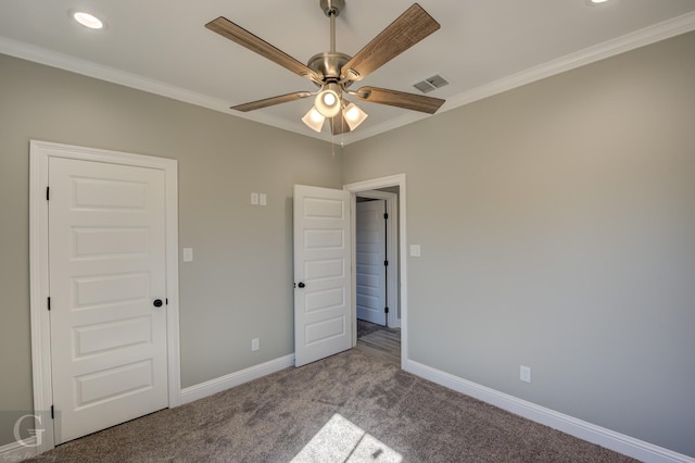 unfurnished bedroom with ornamental molding, carpet, and ceiling fan