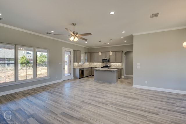 kitchen with gray cabinetry, hanging light fixtures, a kitchen island, stainless steel appliances, and decorative backsplash