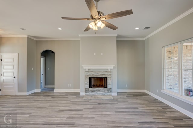 unfurnished living room with crown molding, ceiling fan, and light hardwood / wood-style flooring