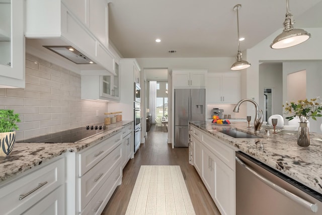 kitchen with sink, white cabinets, decorative light fixtures, custom range hood, and appliances with stainless steel finishes