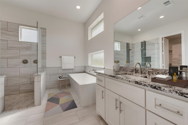 bathroom featuring tile patterned flooring, independent shower and bath, and vanity