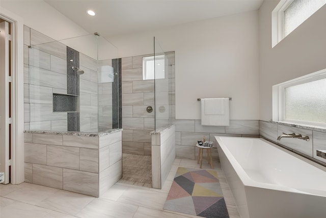 bathroom with independent shower and bath and tile walls