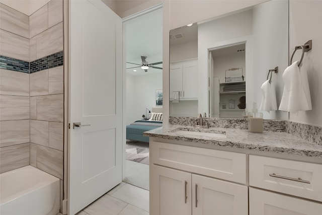 bathroom featuring tiled shower / bath combo, vanity, tile patterned flooring, and ceiling fan