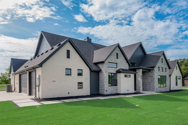 back of house featuring cooling unit, a lawn, and a garage