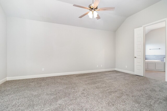 carpeted spare room featuring ceiling fan and vaulted ceiling