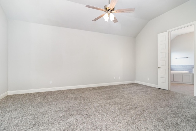 spare room featuring carpet floors, vaulted ceiling, baseboards, and ceiling fan