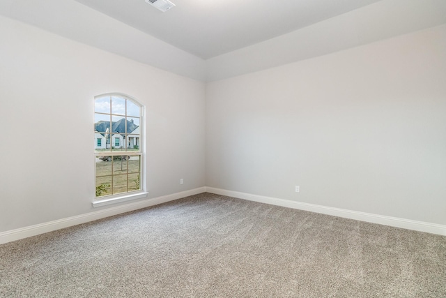 empty room featuring carpet flooring, visible vents, and baseboards