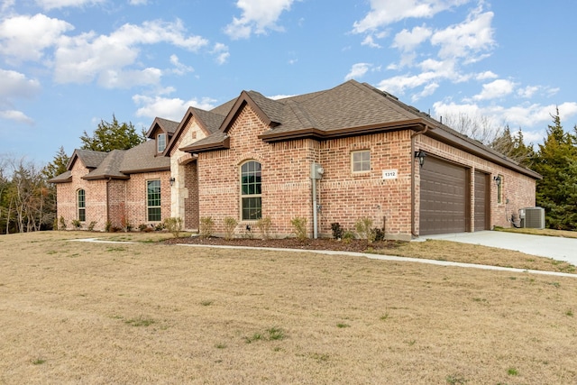 view of front of house featuring a shingled roof, brick siding, driveway, and central AC