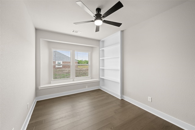 spare room featuring dark wood-type flooring and ceiling fan