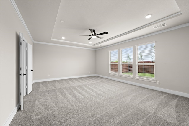 spare room with carpet flooring, ceiling fan, a raised ceiling, and crown molding