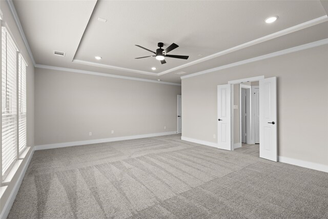 unfurnished room with plenty of natural light, ceiling fan, a tray ceiling, and carpet floors