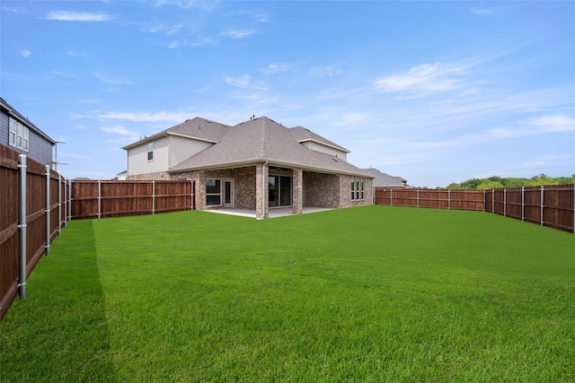 rear view of property featuring a patio and a yard