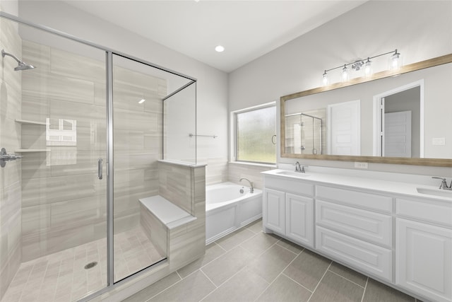 bathroom with double vanity, a garden tub, a sink, and a stall shower