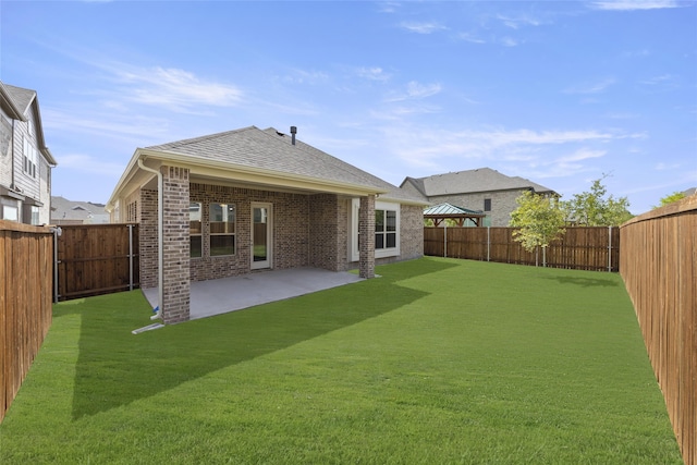 back of property with a yard, a fenced backyard, a patio, and brick siding