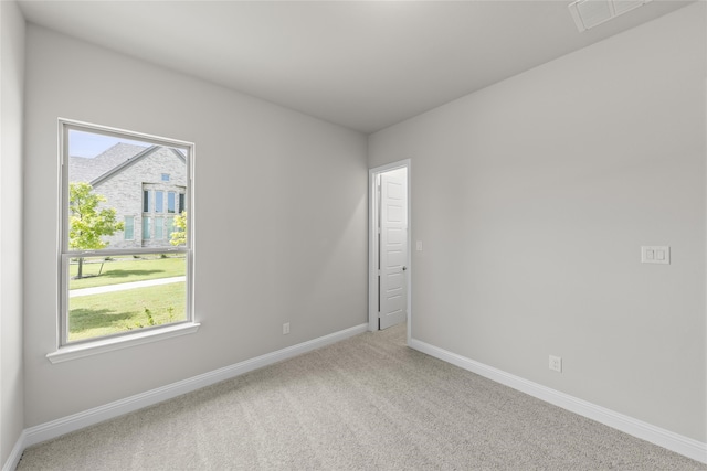 empty room with carpet flooring, visible vents, and baseboards