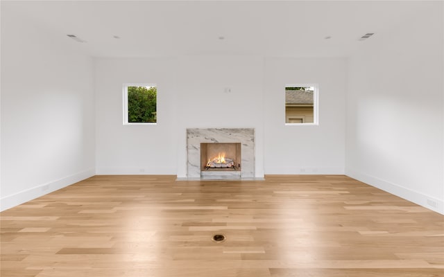 unfurnished living room with light hardwood / wood-style floors and a premium fireplace