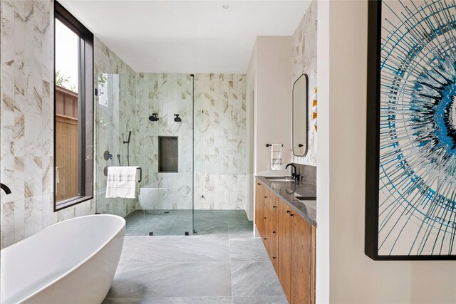 bathroom featuring tile walls, separate shower and tub, tile patterned floors, and double sink vanity