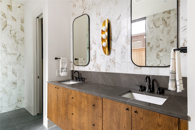 bathroom with dual vanity, tile patterned flooring, and tile walls