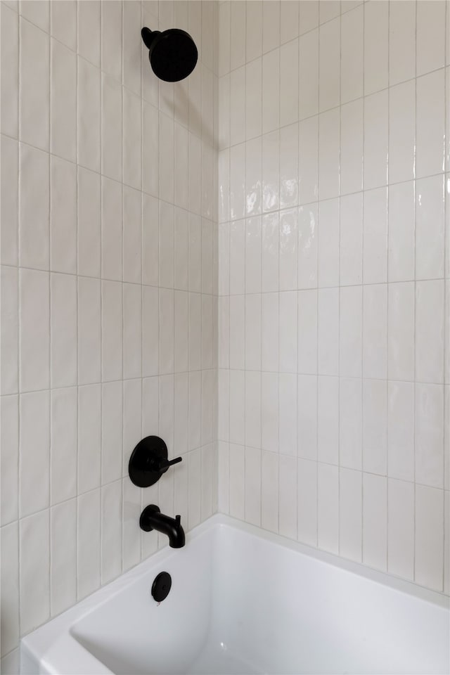 interior details with tiled shower / bath combo