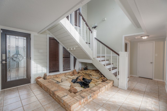 tiled entrance foyer with lofted ceiling and crown molding