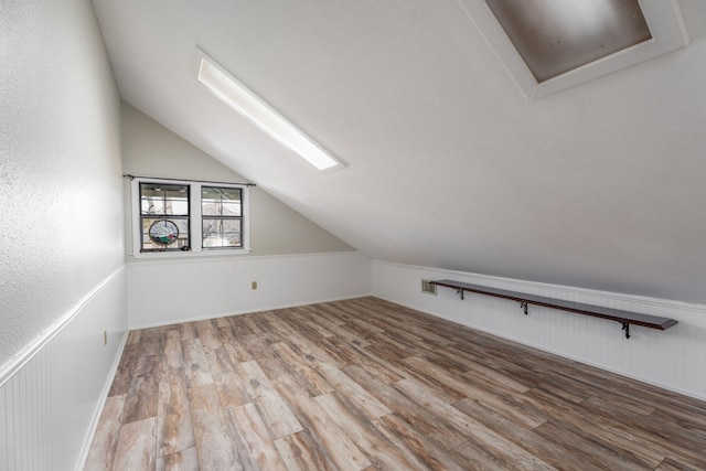 additional living space featuring vaulted ceiling and hardwood / wood-style floors