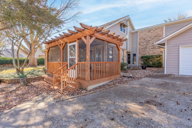 view of front of home with a deck, a pergola, and a sunroom