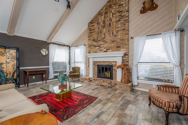 living room featuring hardwood / wood-style flooring, beam ceiling, high vaulted ceiling, and a wealth of natural light