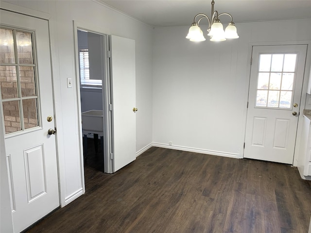 unfurnished dining area featuring dark hardwood / wood-style flooring, ornamental molding, and an inviting chandelier